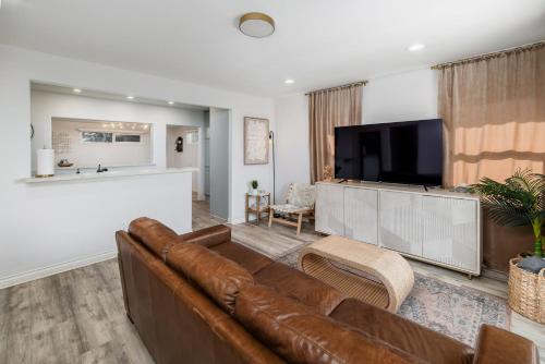 a living room with a brown couch and a flat screen tv at Downtown La Mesa gem in La Mesa