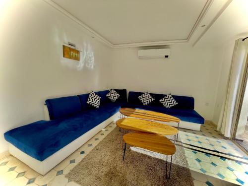 a living room with a blue couch and a table at Villa Paradis in Marrakech