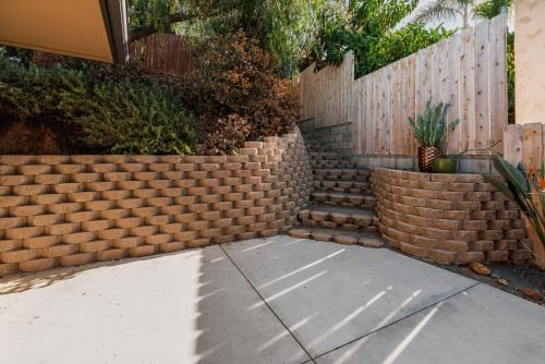 a brick retaining wall next to a fence at Downtown La Mesa gem in La Mesa