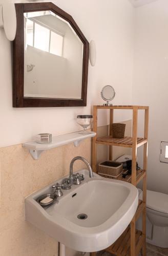 une salle de bain avec un lavabo et un miroir et des toilettes dans l'établissement La serre, à Bard-lès-Époisses