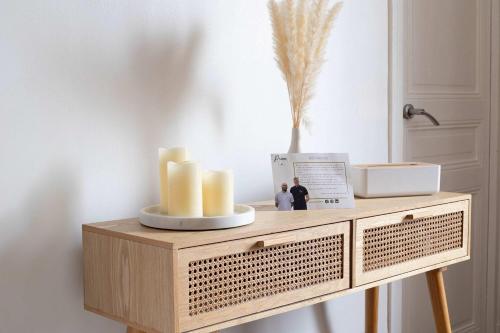 - une table en bois avec des bougies et un vase dans l'établissement Le Théophile - 25 min from Paris, à Le Raincy