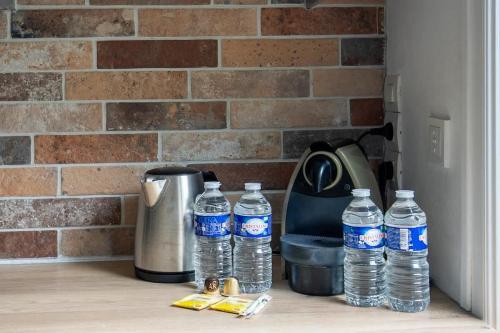 un groupe de bouteilles d'eau assises sur un comptoir dans l'établissement Le Colombier - Balcon, Parking, Seine Musicale, à Sèvres