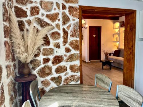 a dining room with a stone wall and a table at Atlazia Suites in Alinda