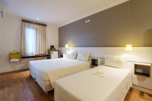 Postel nebo postele na pokoji v ubytování Uniclass Hotel Pinheiros
