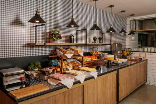a buffet line with many different types of food at Uniclass Hotel Pinheiros in Sao Paulo