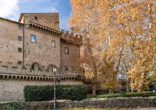 an old castle with trees in front of it at Roma 20min-Elegante Loft Storico Grottaferrata in Grottaferrata