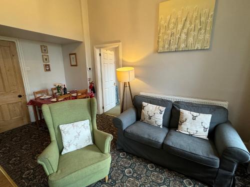 a living room with a couch and two chairs at Hargate Hall Self Catering in Buxton