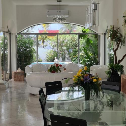 a living room with a white couch and a glass table at Villa Zafiro in Cancún
