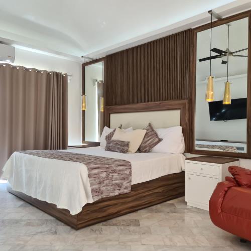 a bedroom with a large bed and a red chair at Villa Zafiro in Cancún