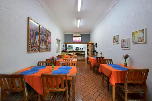 a restaurant with tables and chairs with orange table cloth at Ribeirão Plaza Hotel in Ribeirão Preto