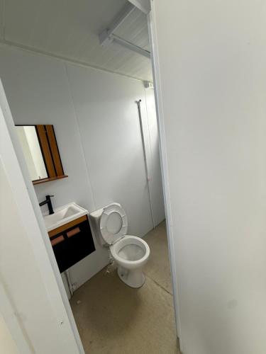 Un baño pequeño con inodoro y lavabo. en Studios Canaã, en Canaã dos Carajás