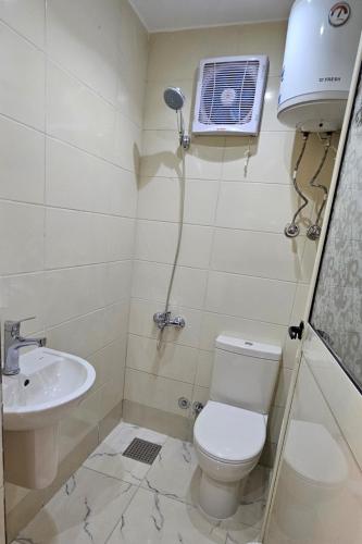 a bathroom with a toilet and a sink at استديو مفروش فرش فندقي in 6th Of October