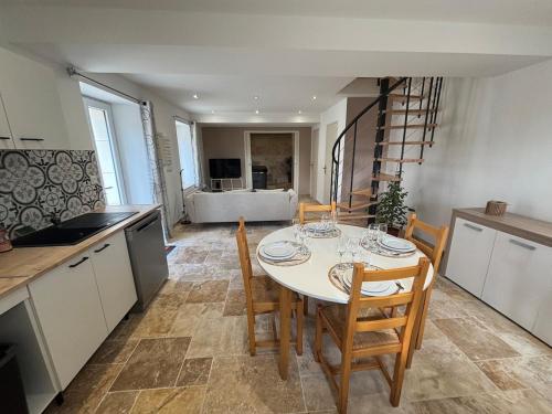 een keuken en eetkamer met een tafel en stoelen bij La Rosace in Saint-Martin-dʼOrdon