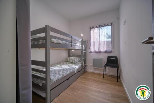 Montclar-sur-GervanneにあるGîte Le Chaudron 1 à 7pers avec piscineの二段ベッド2台と椅子のある寝室