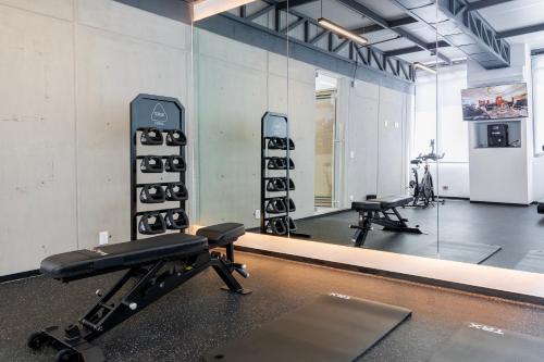 a gym with a mirror and a bench and equipment at Capitalia Hipodromo Condesa in Mexico City