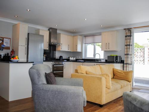 a kitchen with a couch and two chairs in a living room at 4 West Park Mews in Kingsbridge