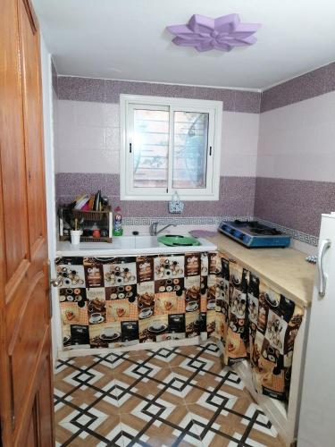 a kitchen with a counter with a patterned floor at Studio Yakina in El Haouaria