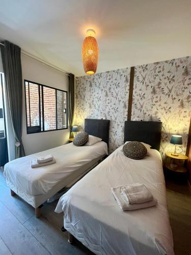 Cette chambre comprend deux lits et un lustre. dans l'établissement Côté Médicis - Cosy appartement au coeur de Blois, à Blois