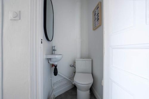 une salle de bain blanche avec des toilettes et un lavabo dans l'établissement Le Dupont - Métro 13, 20 min Champs-Elysées, à Asnières-sur-Seine