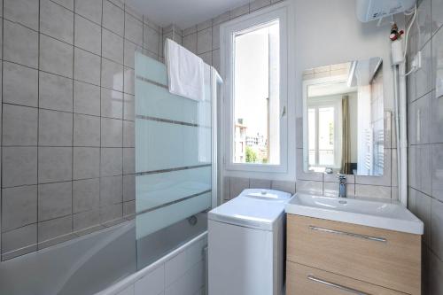 une salle de bain avec un lavabo, des toilettes et un miroir dans l'établissement Le Dupont - Métro 13, 20 min Champs-Elysées, à Asnières-sur-Seine