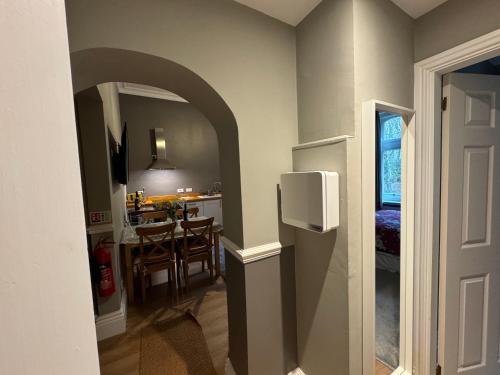 a kitchen and dining room with an archway in a house at Hargate Hall Self Catering in Buxton