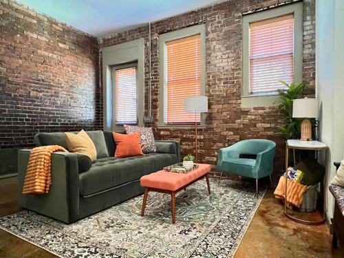 a living room with a couch and a brick wall at Beautifully Modern Townhouse in Historic SPR in Jacksonville
