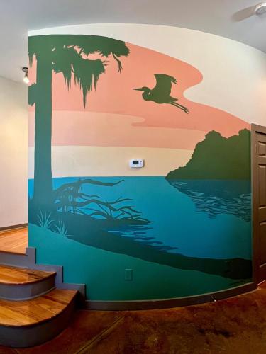 a mural in a room with a tree and a bird at Beautifully Modern Townhouse in Historic SPR in Jacksonville