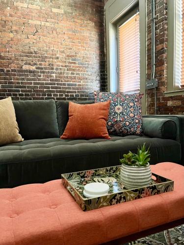 a black couch with pillows and a table at Beautifully Modern Townhouse in Historic SPR in Jacksonville