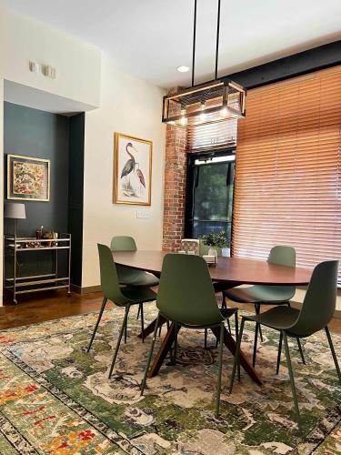 a dining room with a wooden table and green chairs at Beautifully Modern Townhouse in Historic SPR in Jacksonville