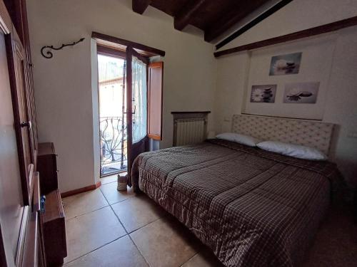 a bedroom with a bed and a large window at La Casetta di Noah in Pratovecchio