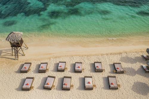 an overhead view of a beach with chairs and the ocean at JOIA Rose Hall by Iberostar - Adults Only All Inclusive Resort in Montego Bay