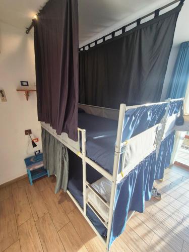 a bedroom with two bunk beds with a canopy at Timbuktu Hostel in San Vito lo Capo