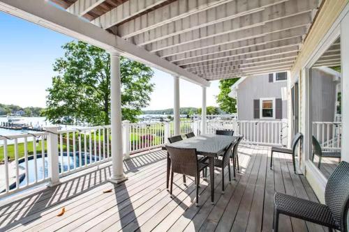 a patio with a table and chairs on a deck at Oasis by the Bay - Waterfront Heated Pool Hot Tub in Annapolis