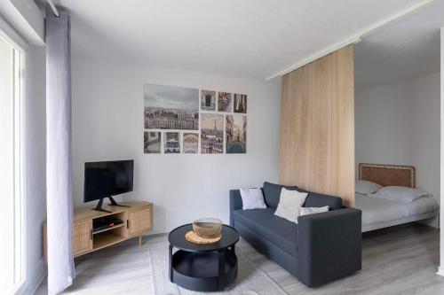 a living room with a couch and a tv at Studio JadOr gare RER B Le Bourget - Paris aeroport Charles de Gaulle in Le Bourget
