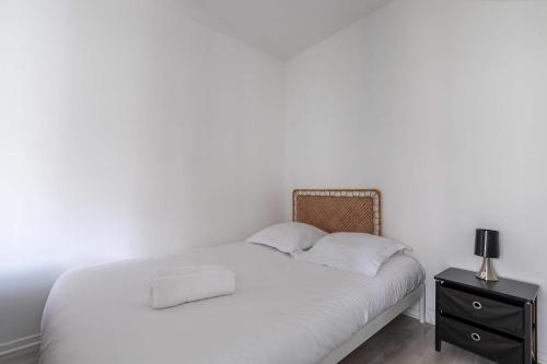 - une chambre blanche avec un lit et une table de chevet dans l'établissement Studio JadOr gare RER B Le Bourget - Paris aeroport Charles de Gaulle, au Bourget