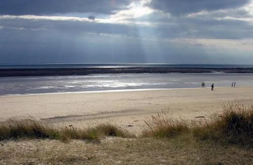 a group of people walking on the beach at Détente à Portbail in Portbail