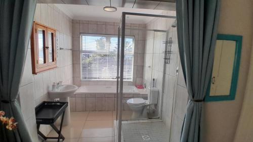 Un baño con bañera, inodoro y lavabo. en View from the Hill room 1, en Mossel Bay