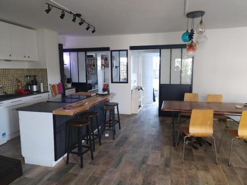 une cuisine et une salle à manger avec une table et des chaises dans l'établissement Appartement Le Bouscat, à Le Bouscat