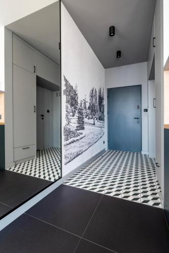 a hallway with white walls and a blue door at Apartamenty Rocha in Pabianice