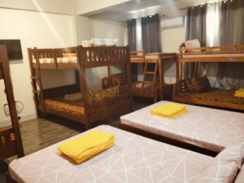 a room with three bunk beds with yellow towels at Mountain cove villa in Pagudpud