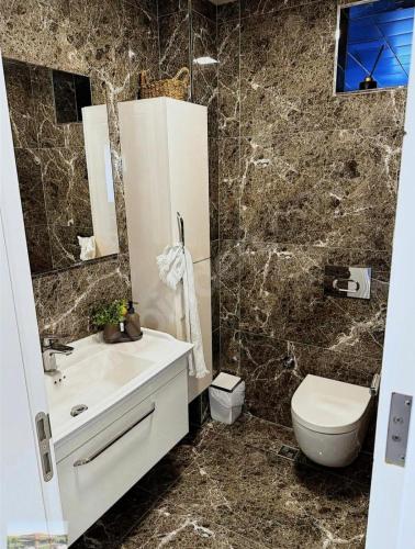 a bathroom with a white sink and a toilet at selimpiya villaları in Silivri