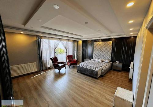 a bedroom with a bed and a desk and chairs at selimpiya villaları in Silivri