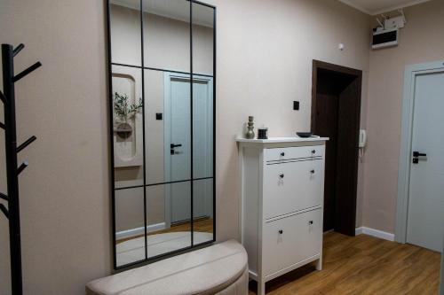 ein Badezimmer mit einem Glasschrank und einer weißen Kommode in der Unterkunft Golden Light - 3BR Luxury Central in Bŭnzareto
