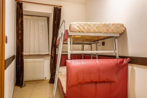 a room with two bunk beds and a red chair at Residence Orizzonte in Vaneze