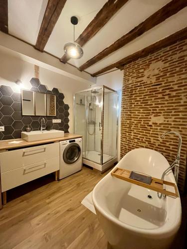 La salle de bains est pourvue d'une baignoire, d'un lavabo et d'un lave-linge. dans l'établissement La Porte Chartraine - Appartement avec terrasse au coeur de Blois, à Blois