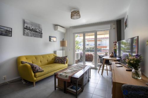 un salon avec un canapé jaune et une table dans l'établissement Air-conditioned apartment near Libération district, à Nice