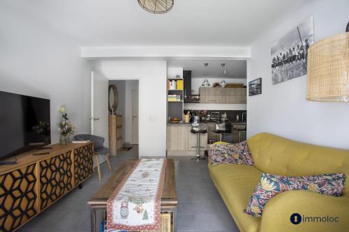 - un salon avec un canapé jaune et une télévision dans l'établissement Air-conditioned apartment near Libération district, à Nice