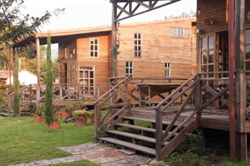 a wooden house with a wooden staircase in the yard at Cabañas ecológicas Xuetama in Villa de Leyva