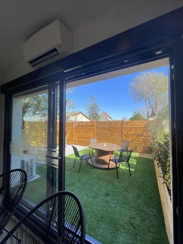 a screened in porch with a table and chairs at Gîte nature M&J in Calais