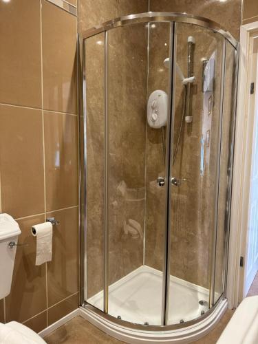 a shower with a glass door in a bathroom at The Calder House Hotel in Seascale